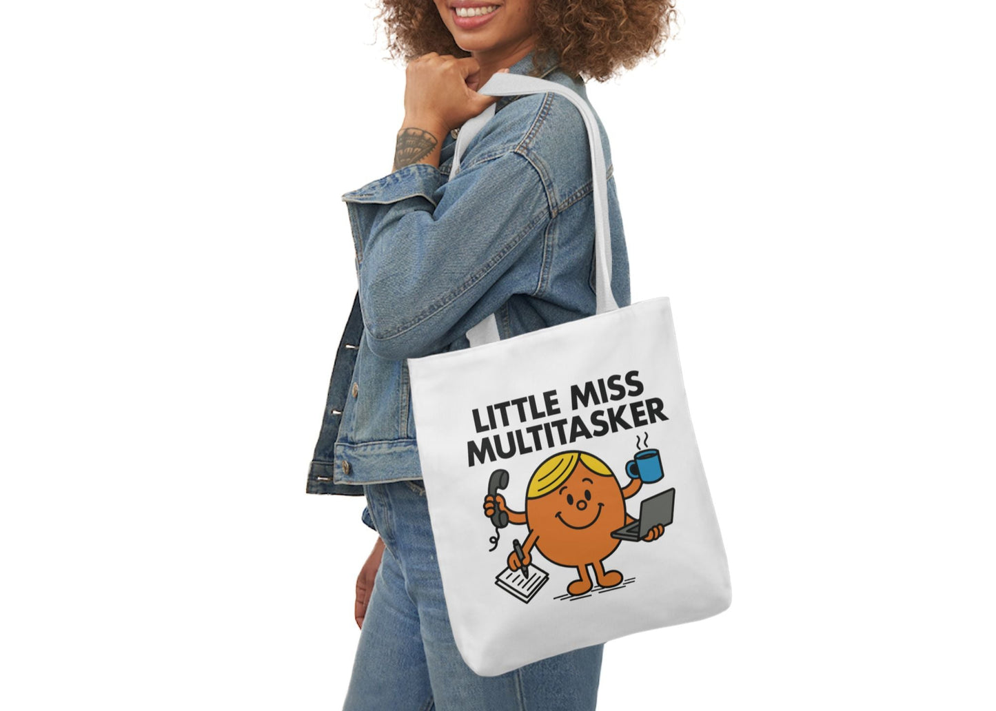 Woman in denim modeling the Little Miss Multitasker tote over her shoulder. She’s booked, busy, and absolutely balancing it all. Part of the Vivid Divergence Little Miss Meme Collection!