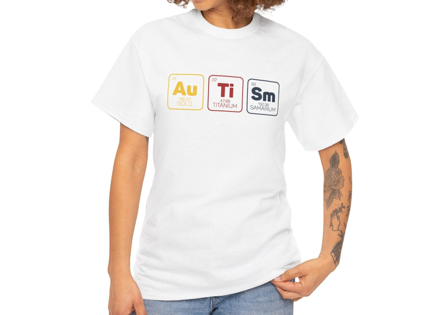 Woman with curly hair wearing a white "Au Ti Sm" periodic table Autism T-shirt, smiling and posing casually. Part of the Vivid Divergence Sensory Friendly Unisex Tees Range.