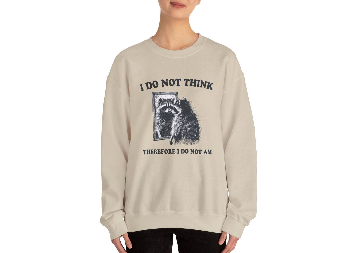 Model wearing a beige sweater jumper with the text "I Do Not Think, Therefore I Do Not Am" and a cartoon raccoon illustration. Part of the Vivid Divergence Sensory Friendly Unisex Sweater Jumper Range.