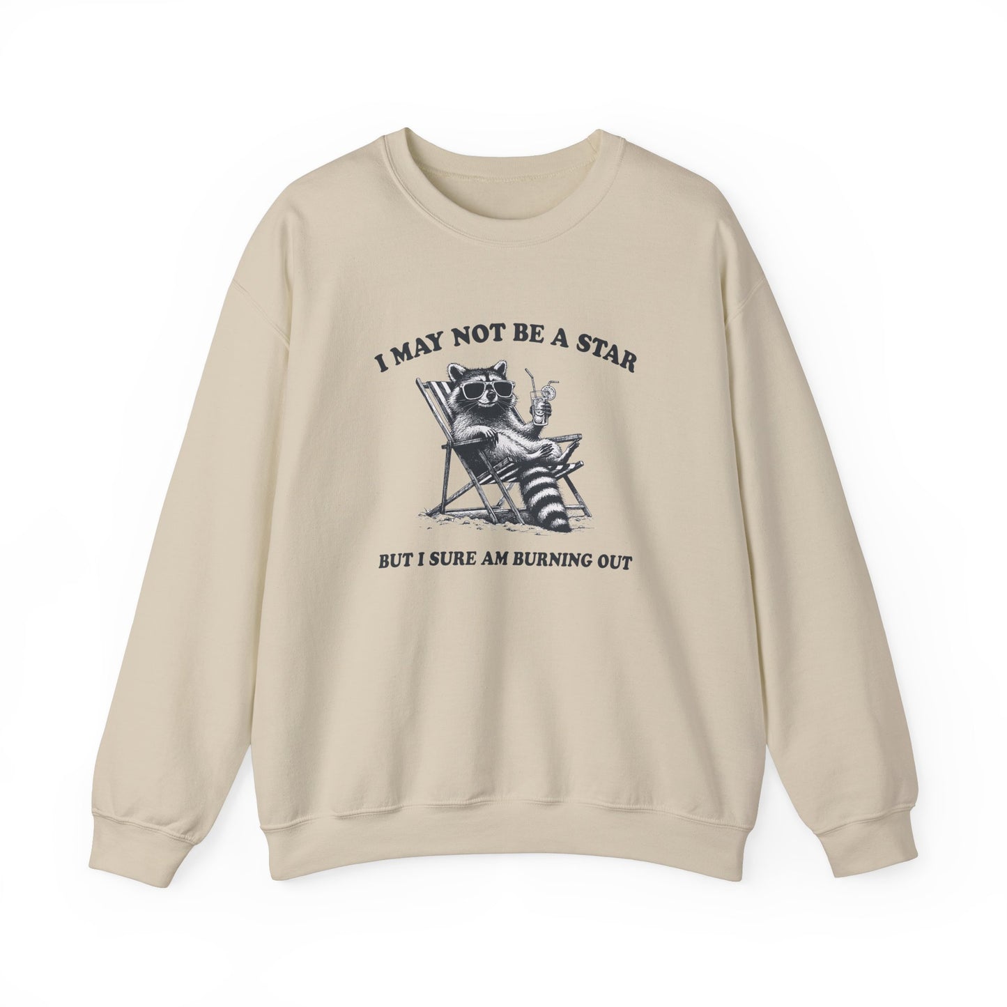 Front view of a beige sweatshirt featuring a raccoon sitting in a trash can with the text "I May Not Be A Star, But I Sure Am Burning Out." Part of the Vivid Divergence Sensory Friendly Unisex Sweater Jumper Range.