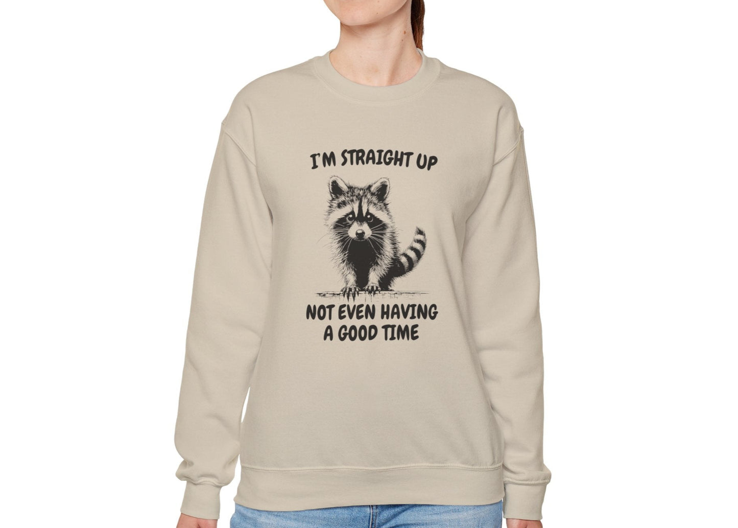 Model wearing a beige sweater jumper with the text "I'm Straight Up Not Even Having a Good Time" and a cartoon raccoon illustration. Part of the Vivid Divergence Sensory Friendly Unisex Sweater Jumper Range.