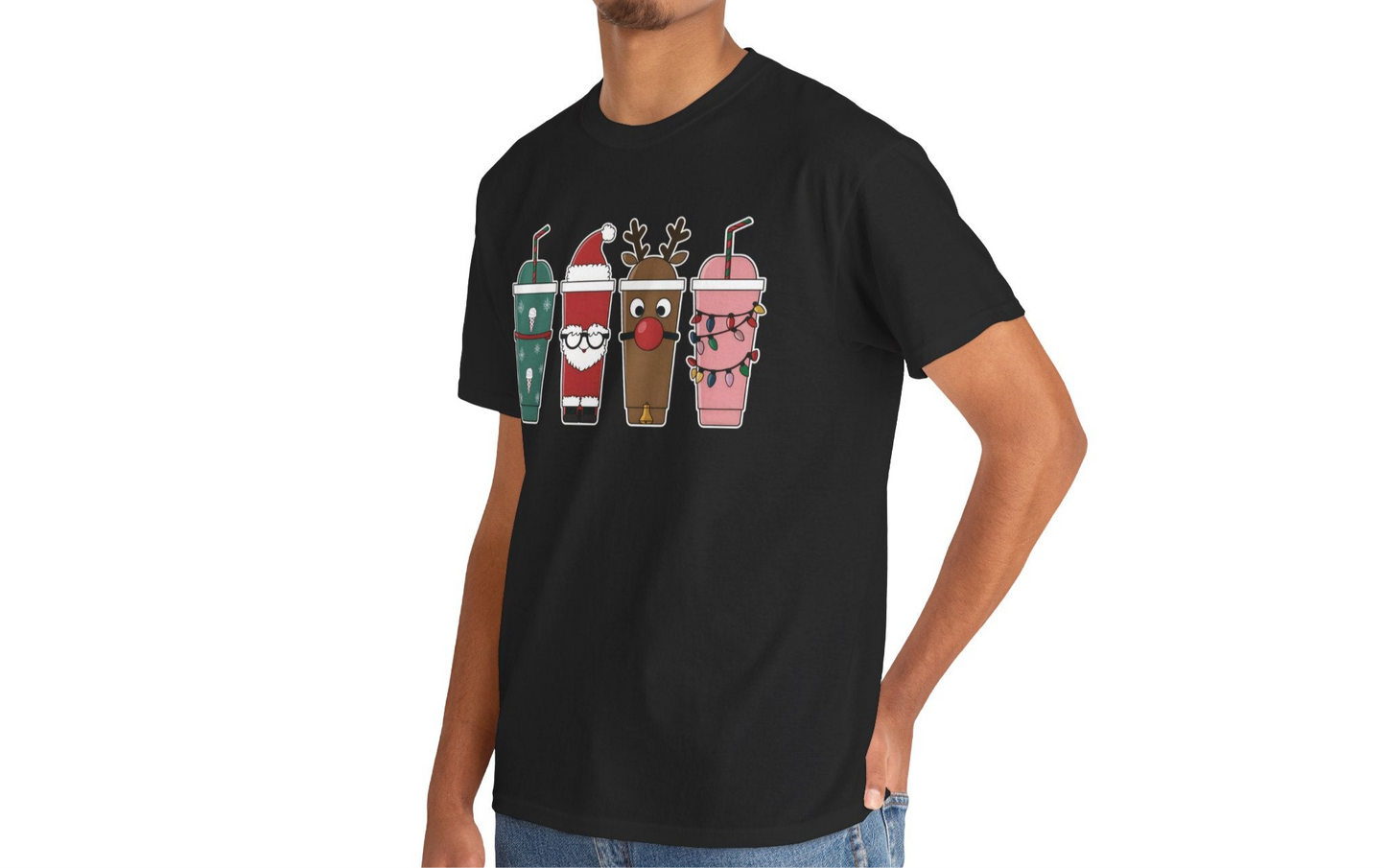 Model wearing a pink T-shirt featuring a festive illustration of four iced coffee cups decorated with Christmas designs, styled in a cozy indoor setting. Part of the Vivid Divergence Sensory Friendly Unisex Tees Range.