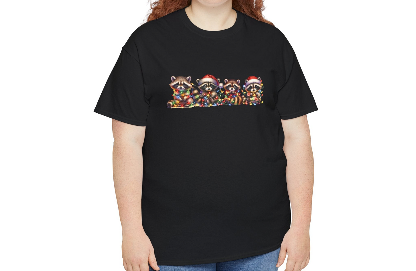 Model wearing a black T-shirt featuring a festive illustration of raccoons in Christmas attire causing holiday chaos, styled casually. Part of the Vivid Divergence Sensory Friendly Unisex Tees Range.