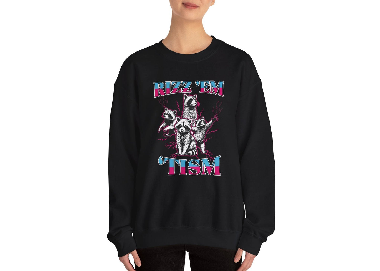 Model wearing a black sweater jumper with the text "Rizz 'Em 'Tism" and a cartoon raccoon illustration striking a pose. Part of the Vivid Divergence Sensory Friendly Unisex Sweater Jumper Range.