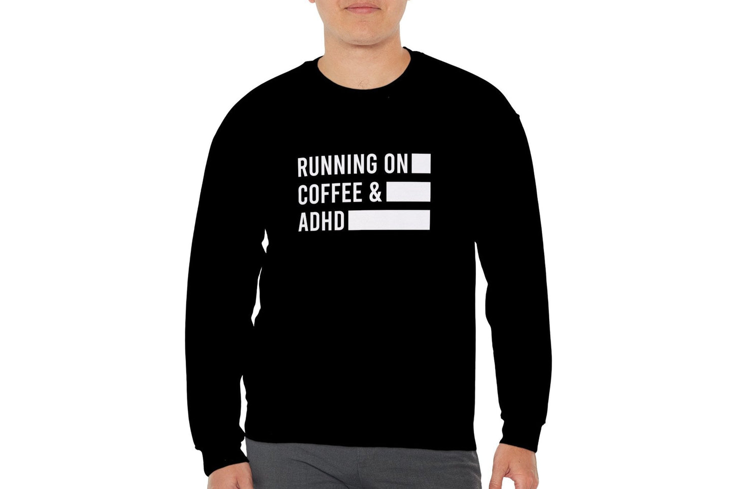 Model wearing a black sweater jumper with the text "Running on Coffee & ADHD" in bold white lettering and a battery graphic. Part of the Vivid Divergence Sensory Friendly Unisex Sweater Jumper Range.