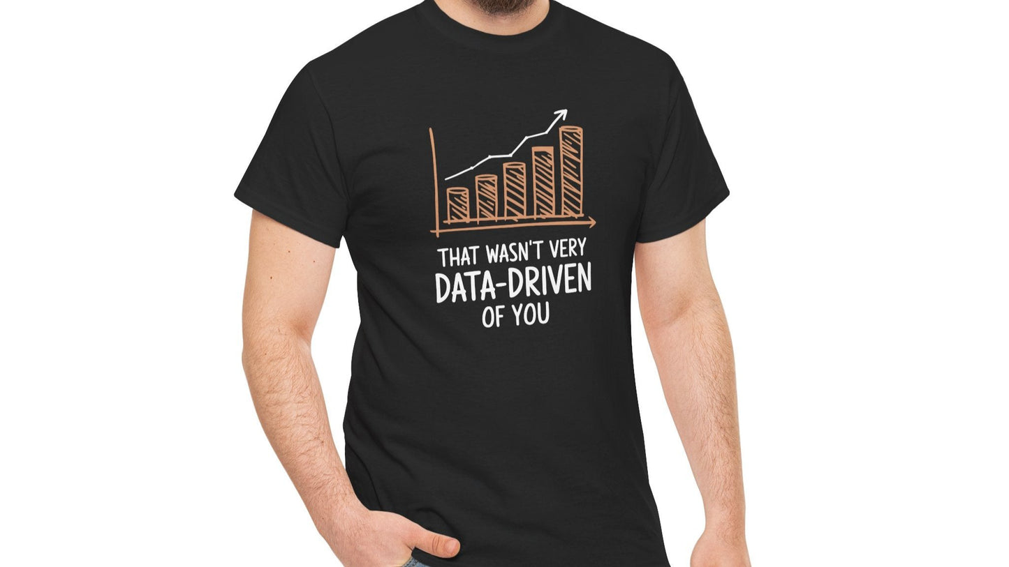 Model wearing a black T-shirt with the text "That Wasn't Very Data-Driven of You" in white, featuring a graphic of a declining bar chart in orange. Part of the Vivid Divergence Sensory Friendly Unisex Tees Range.