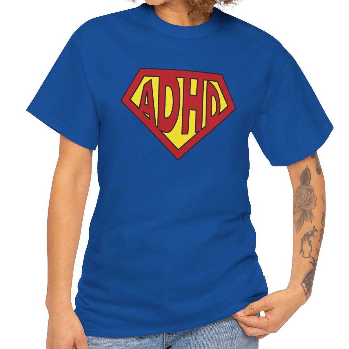 Side view of a blue T-shirt featuring a yellow and red ADHD logo styled in the Superman symbol. Part of the Vivid Divergence Sensory Friendly Unisex Tees Range.