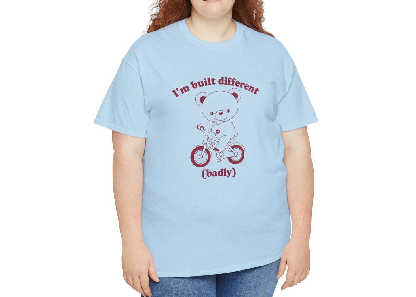 Model wearing a blue T-shirt with the "Built Different (Badly)" bear design. Part of the Vivid Divergence Sensory Friendly Unisex Tees Range.