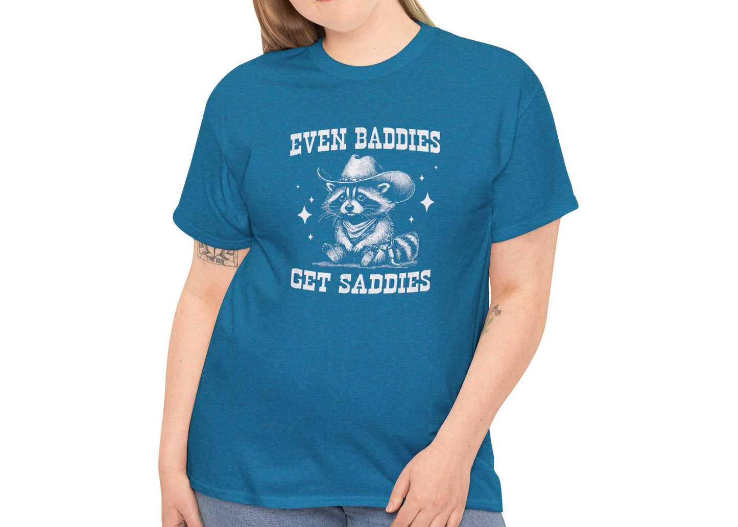 Model wearing a blue T-shirt with "Even Baddies Get Saddies" text and crying eye design. Part of the Vivid Divergence Sensory Friendly Unisex Tees Range.