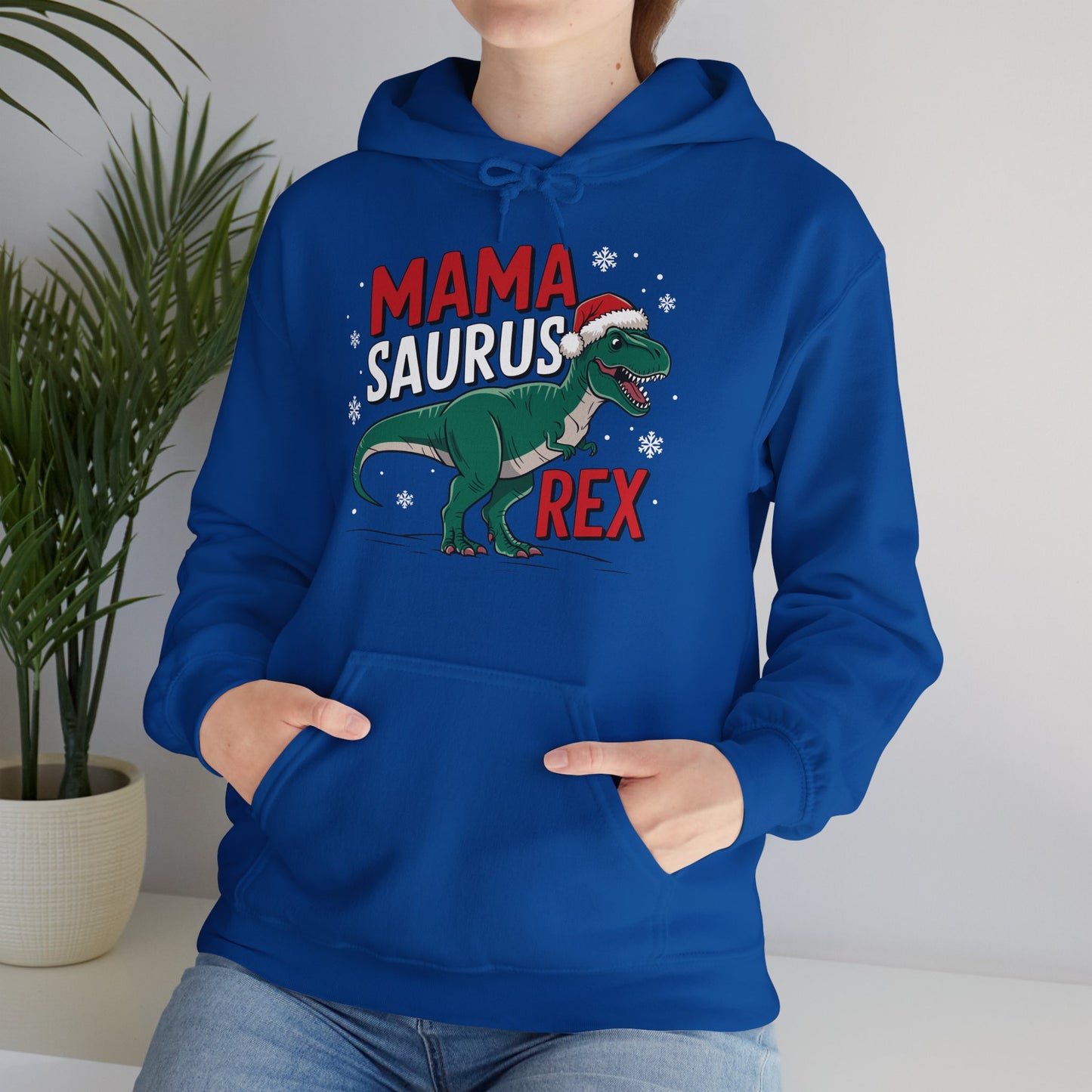 Model wearing a blue hoodie featuring a "Mama-Saurus Rex" design with a festive dinosaur illustration, styled casually. Part of the Vivid Divergence Sensory Friendly Unisex Hoodie Range.