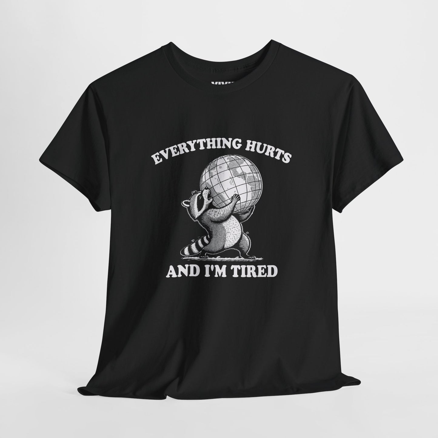 Hanging view of black T-shirt featuring a vintage style sketch of a raccoon carrying the world with the phrase “Everything Hurts and I’m Tired.” The official uniform of burnt out. Part of the Vivid Divergence Memewear Collection!