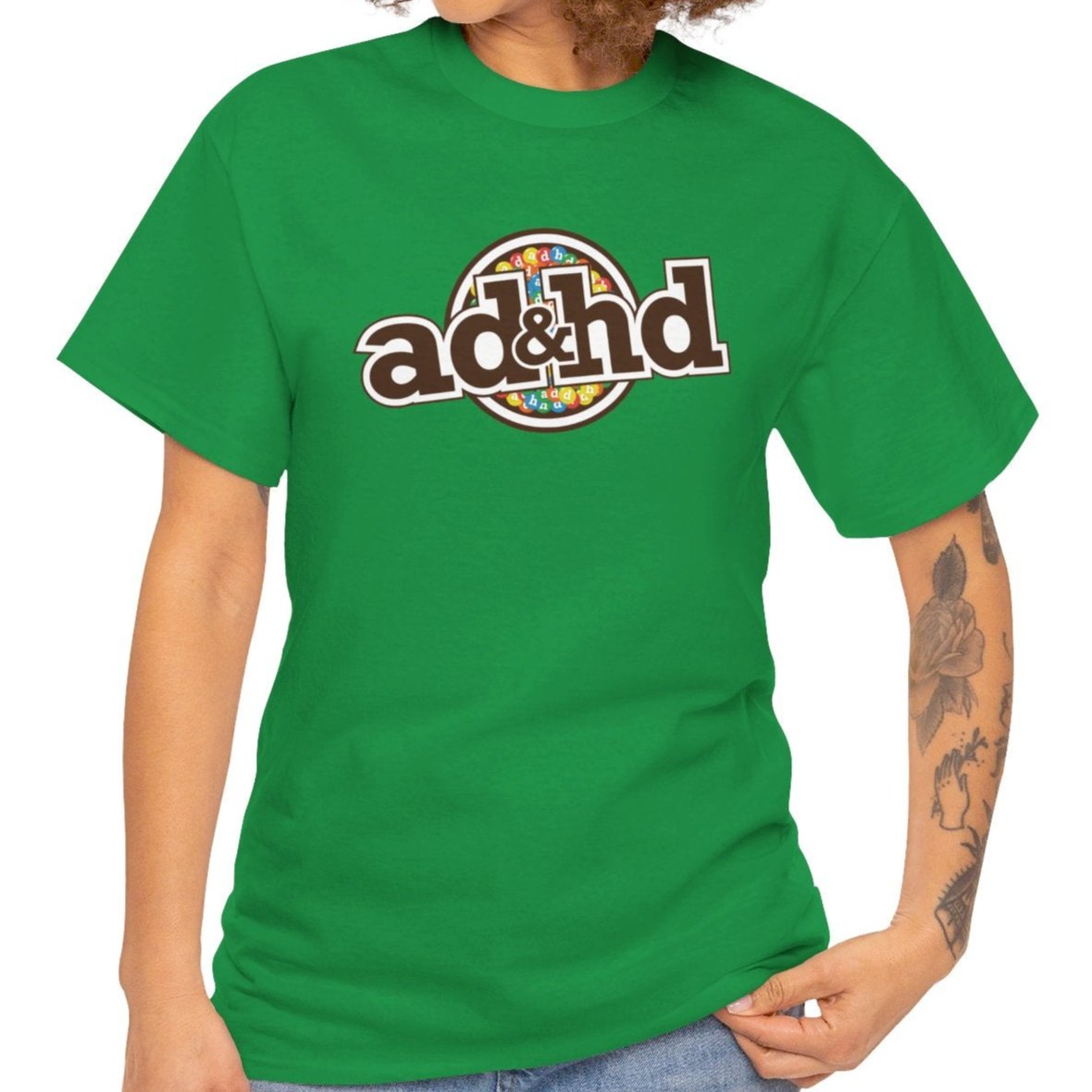 Female model wearing a green ADHD parody T-shirt inspired by m&m candy branding. Part of the Vivid Divergence Sensory Friendly Unisex Tees Range.