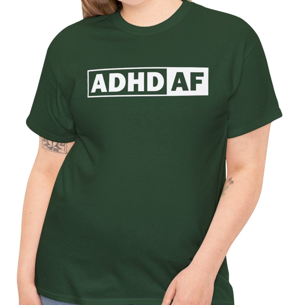 Model wearing a forest green T-shirt with bold "ADHD AF" text. Part of the Vivid Divergence Sensory Friendly Unisex Tees Range.