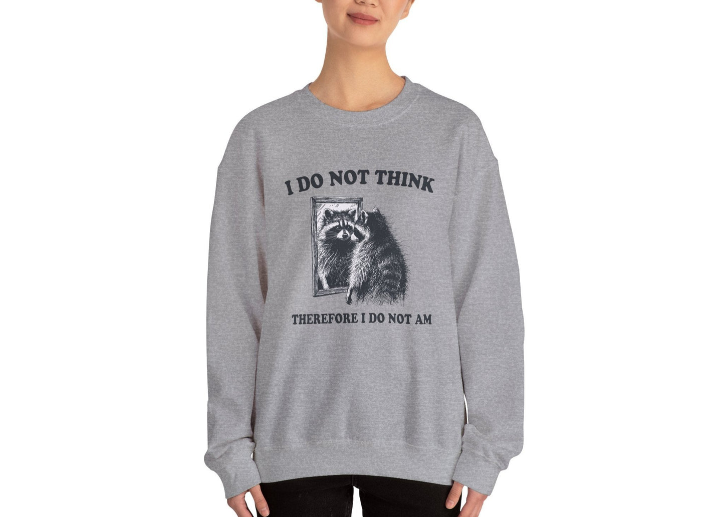 Model wearing a gray sweater jumper with the text "I Do Not Think, Therefore I Do Not Am" and a cartoon raccoon illustration. Part of the Vivid Divergence Sensory Friendly Unisex Sweater Jumper Range.