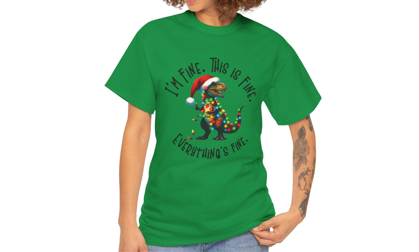Model wearing an green T-shirt featuring a festive illustration of a dinosaur tangled in Christmas lights with the text "I’m Fine. This is Fine. Everything is Fine," styled casually. Part of the Vivid Divergence Sensory Friendly Unisex Tees Range.