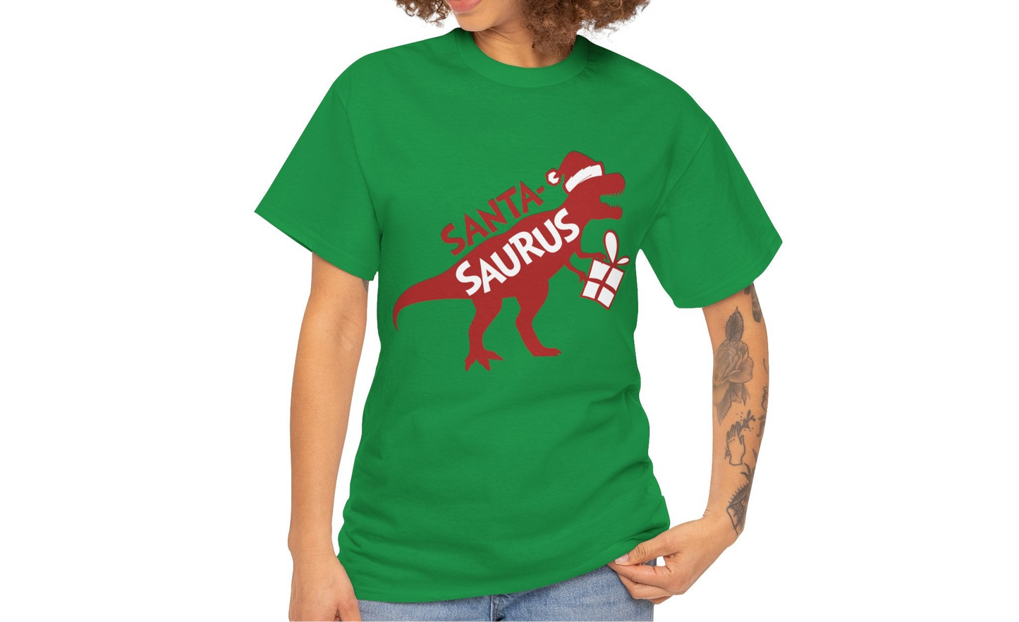 Model wearing a green T-shirt featuring a "Santa-Saurus Rex" design with a red dinosaur wearing a Santa hat and carrying a gift. Part of the Vivid Divergence Sensory Friendly Unisex Tees Range.