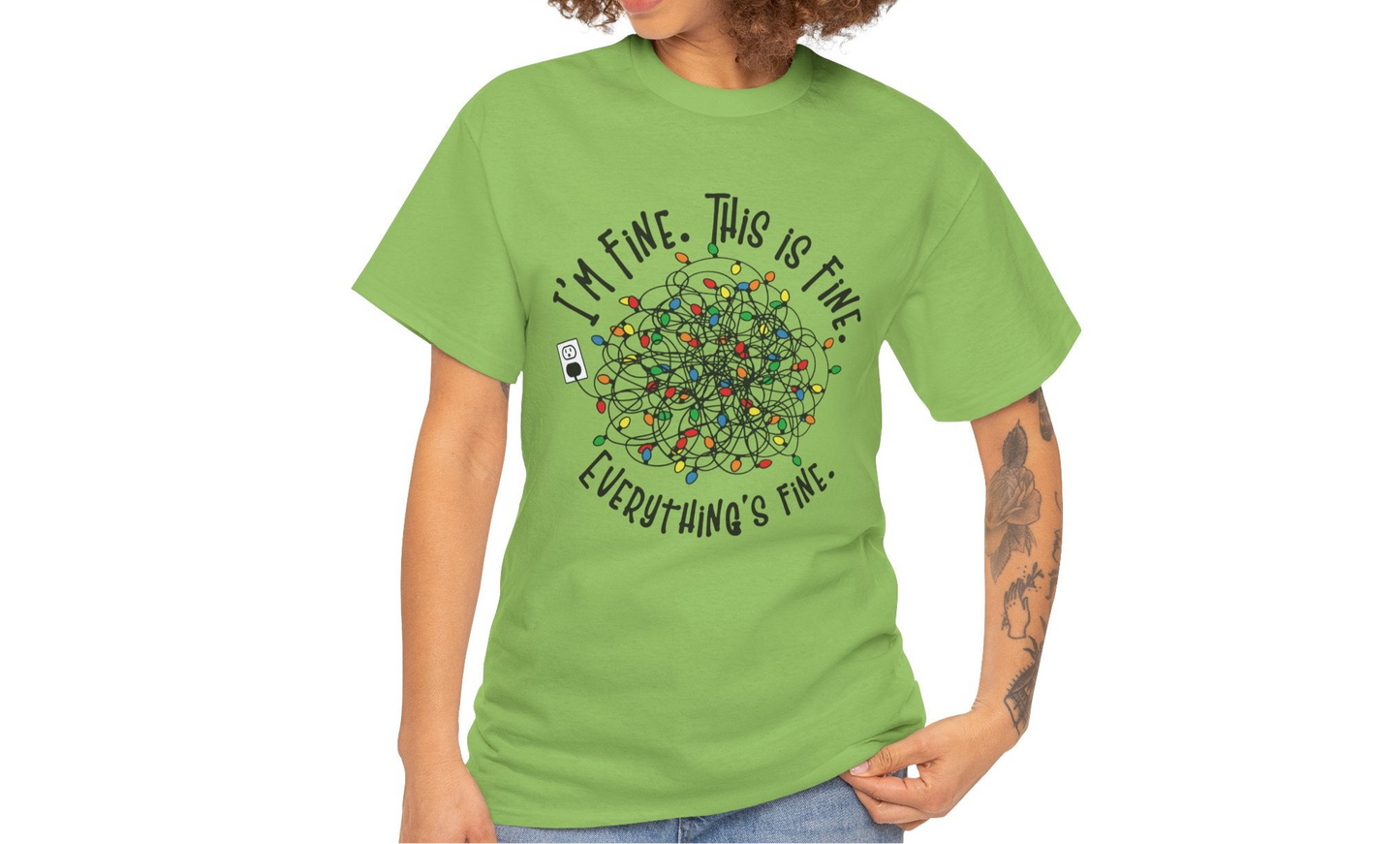 Model wearing a green T-shirt with a festive tangled Christmas lights design and the phrase "I'm Fine. This is Fine. Everything's Fine." Part of the Vivid Divergence Sensory Friendly Unisex Tees Range