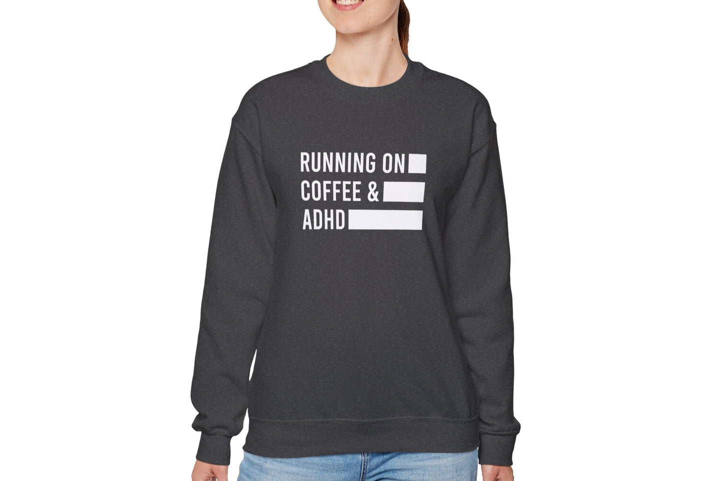 Model wearing a grey sweater jumper with the text "Running on Coffee & ADHD" in bold white lettering and a battery graphic. Part of the Vivid Divergence Sensory Friendly Unisex Sweater Jumper Range.
