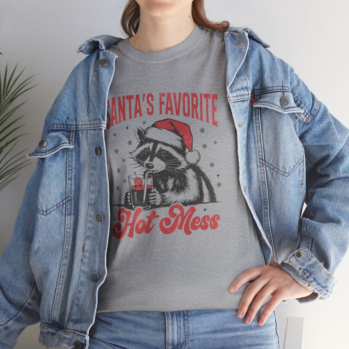 Model wearing a grey T-shirt with a denim jacket, featuring a "Santa's Favorite Hot Mess" design with a festive raccoon wearing a Santa hat. Part of the Vivid Divergence Sensory Friendly Unisex Tees Range.