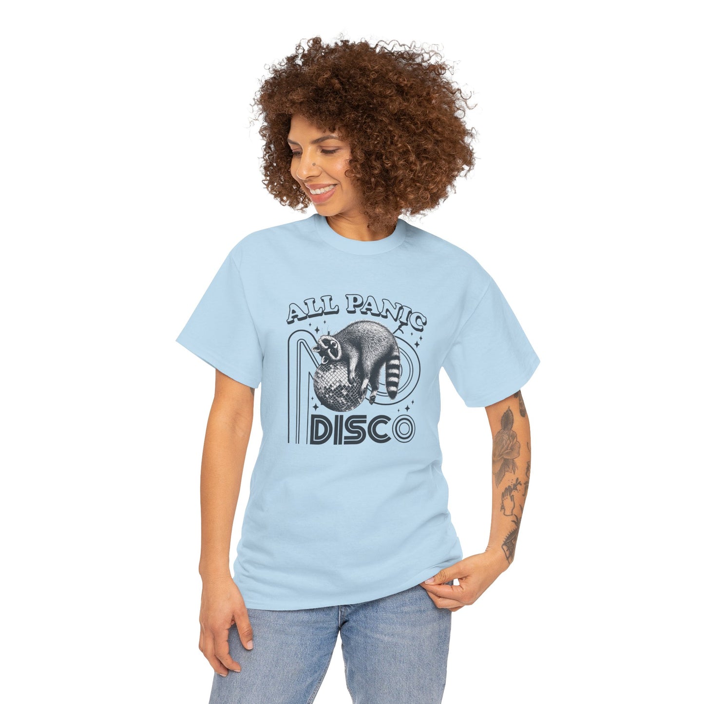Model wearing a light blue T-shirt featuring "All Panic No Disco" text with a raccoon illustration inside a disco ball. Part of the Vivid Divergence Sensory Friendly Unisex Tees Range.