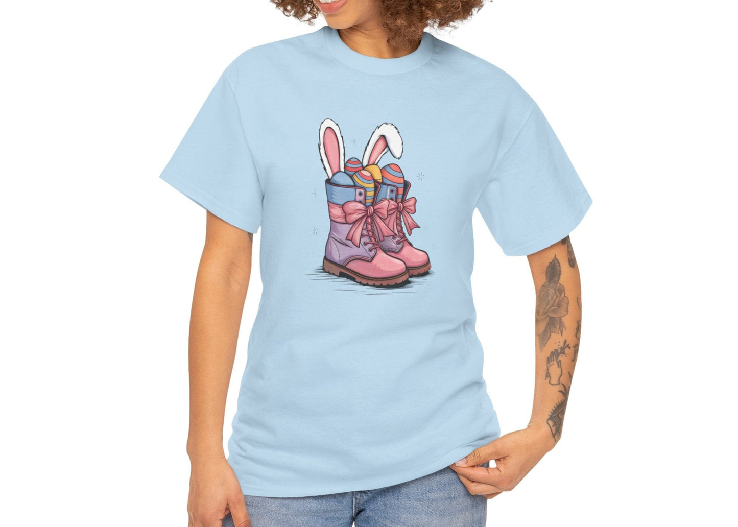 Woman wearing a Light Blue Easter T-shirt displaying a cowgirl boots design with bunny ears and Easter eggs, a stylish seasonal look. Hop into the season in style and shop Easter shirts online today!