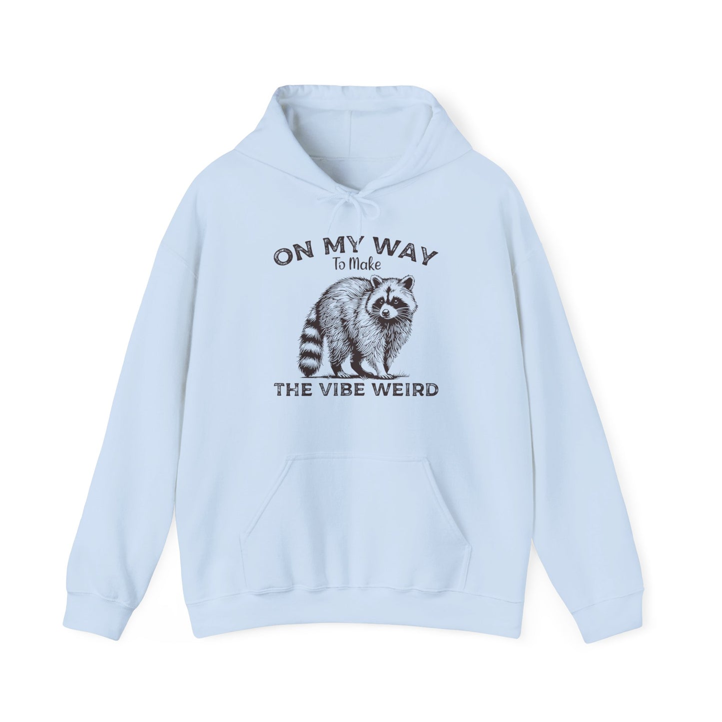 Front view of a light blue hoodie featuring the text "On My Way to Make the Vibe Weird" and a cartoon illustration of a raccoon holding a stick. Part of the Vivid Divergence Sensory Friendly Unisex Hoodie Range.