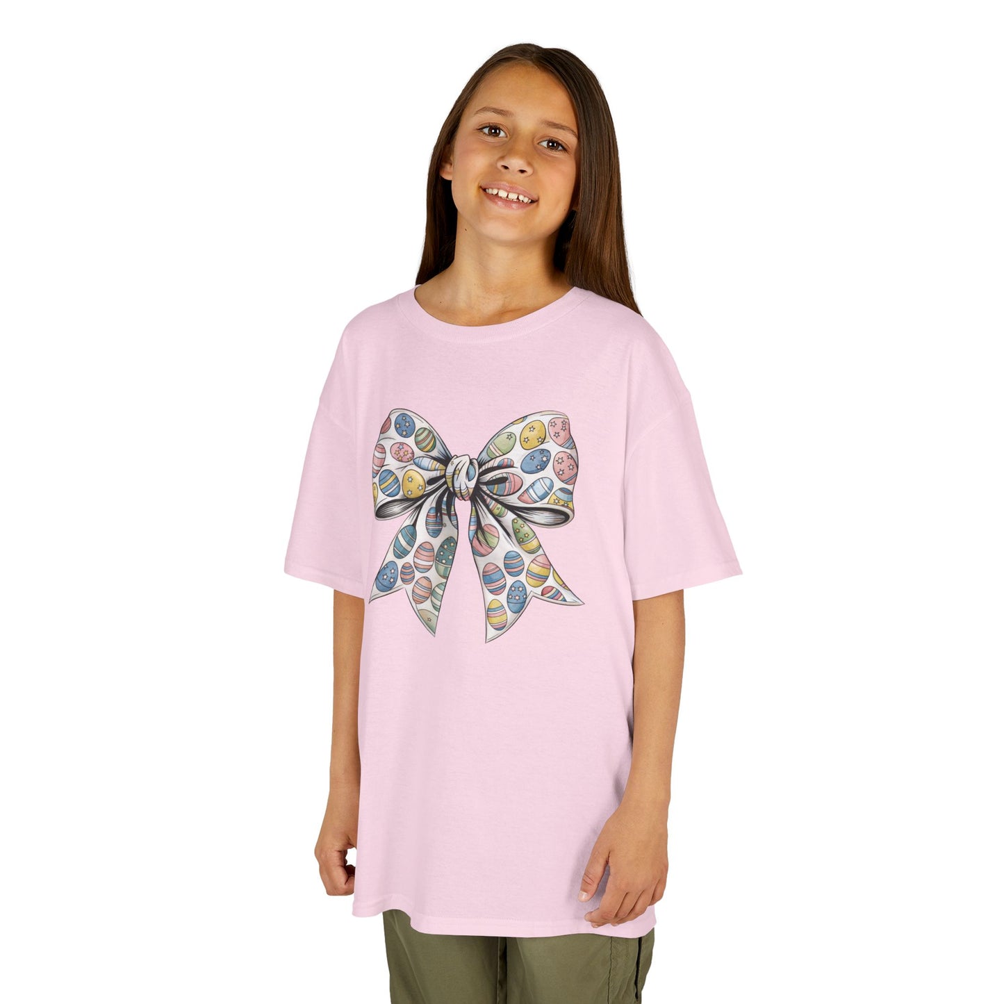 Child wearing a light pink Easter T-shirt featuring a soft floral bow in a coquette aesthetic, a dreamy Easter outfit. Hop into the season in style and shop Easter shirts online today!