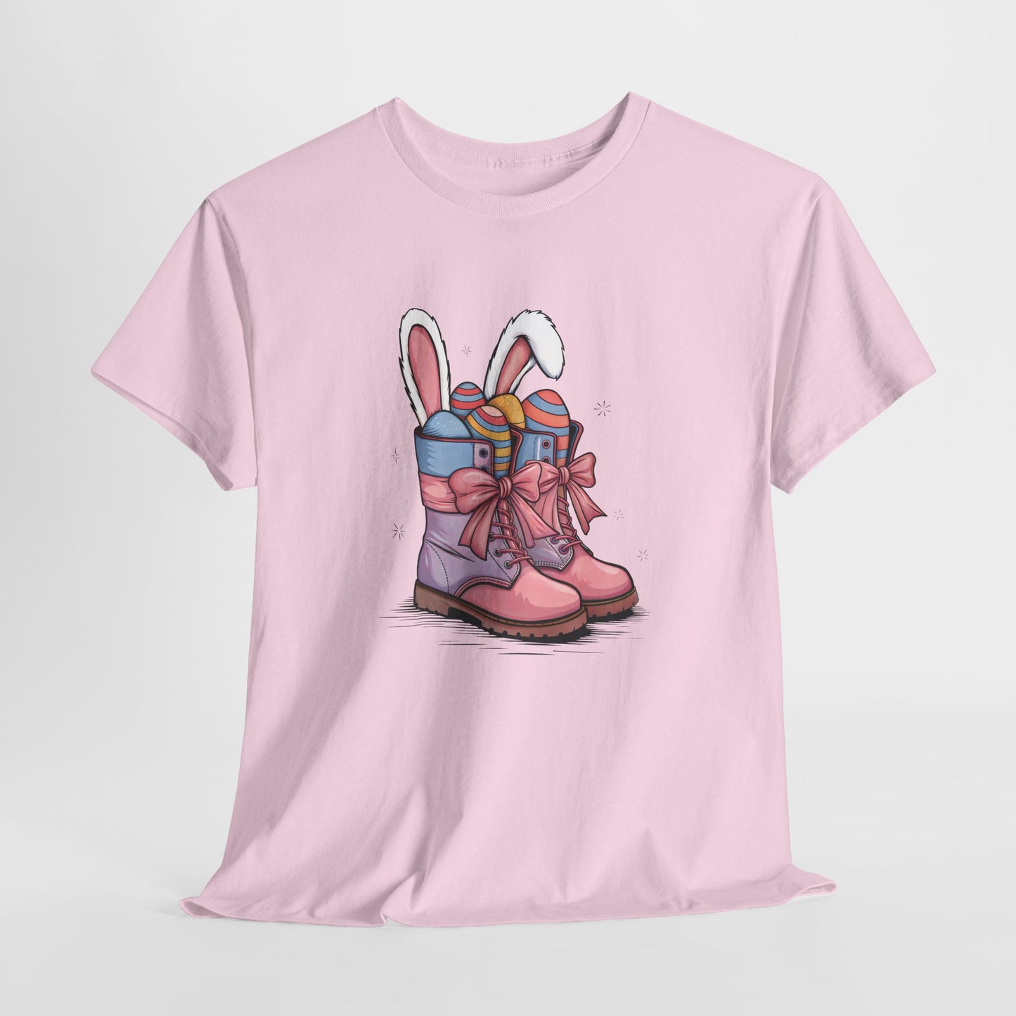 Light Pink T-shirt hanging, decorated with Easter cowgirl boots, bunny ears, and colorful eggs, a cute and trendy spring tee. Hop into the season in style and shop Easter shirts online today!