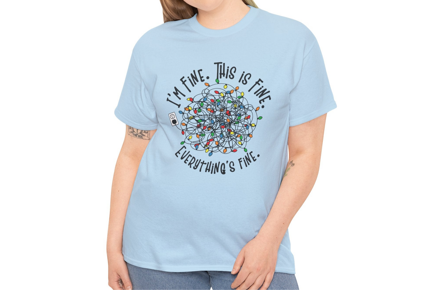 Model wearing a light blue T-shirt with a colorful tangled Christmas lights design and the phrase "I'm Fine. This is Fine. Everything's Fine." Part of the Vivid Divergence Sensory Friendly Unisex Tees Range.