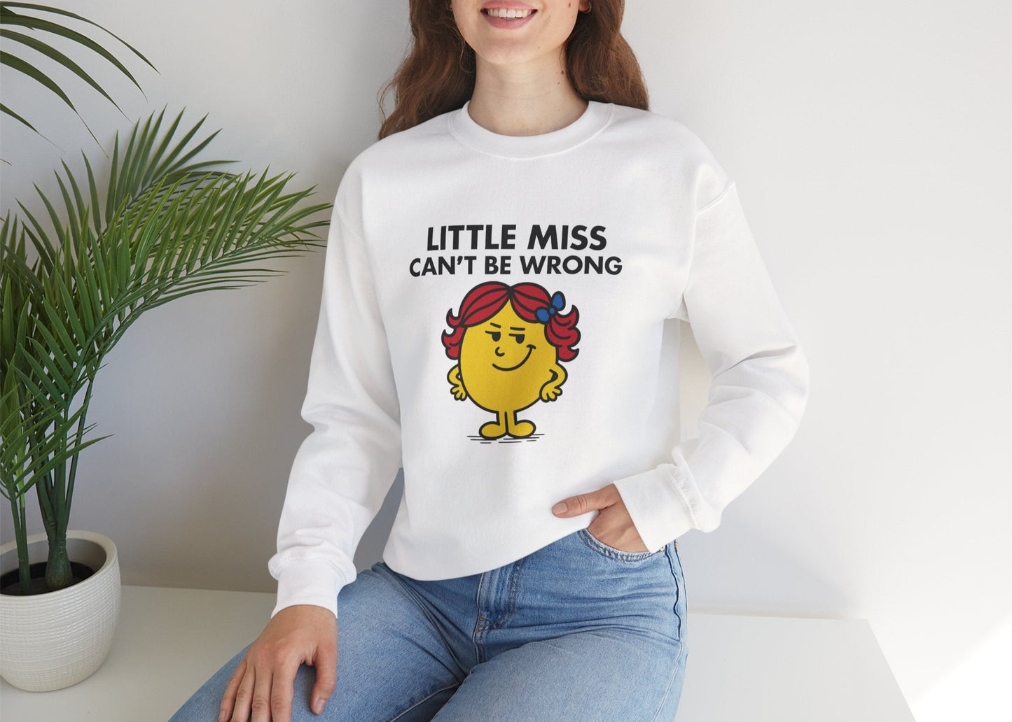 son wearing the Little Miss Can’t Be Wrong sweatshirt while seated casually. Part of the Little Miss Meme Character Collection. A Vivid Divergence Sensory Friendly Sweater Jumper.