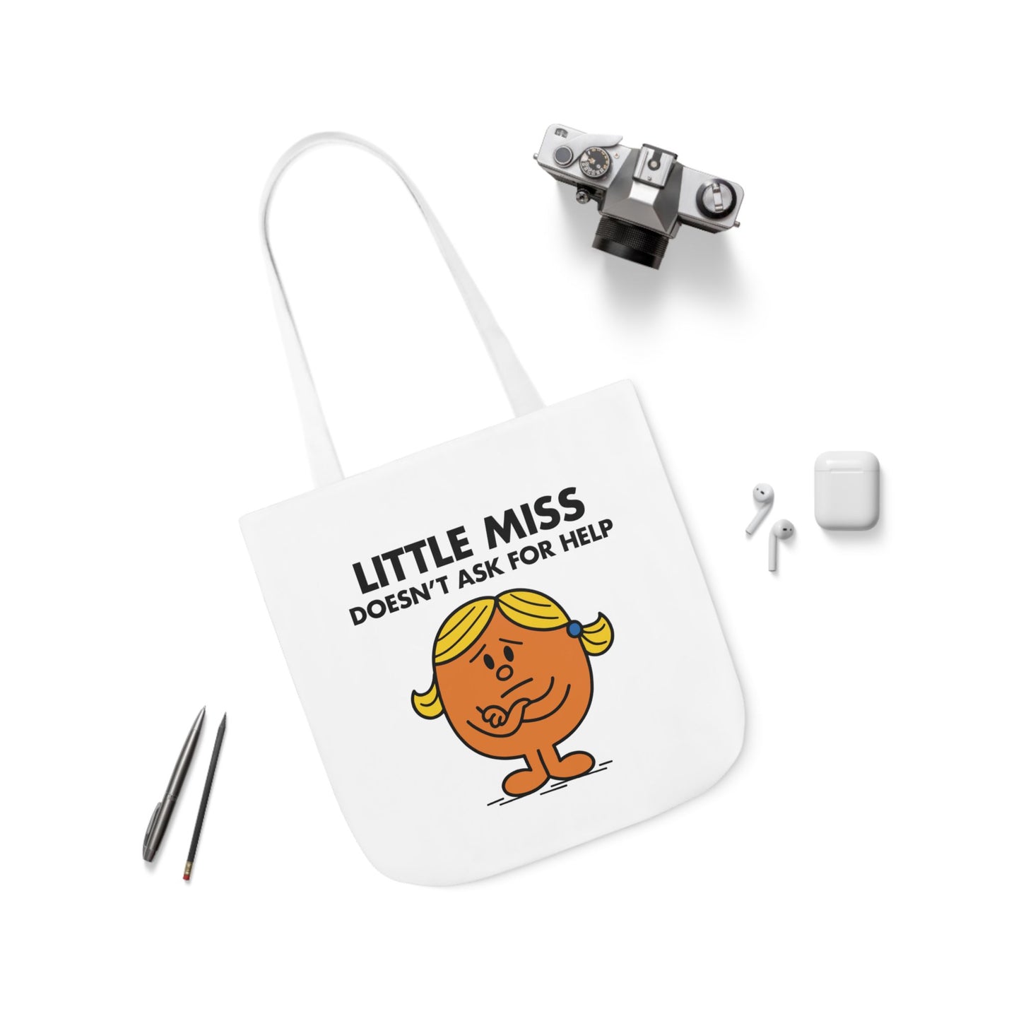 Flat lay of tote bag with Little Miss Doesn’t Ask For Help surrounded by accessories. She’ll Google it for two hours before admitting she’s lost. Part of the Vivid Divergence Little Miss Meme Collection!