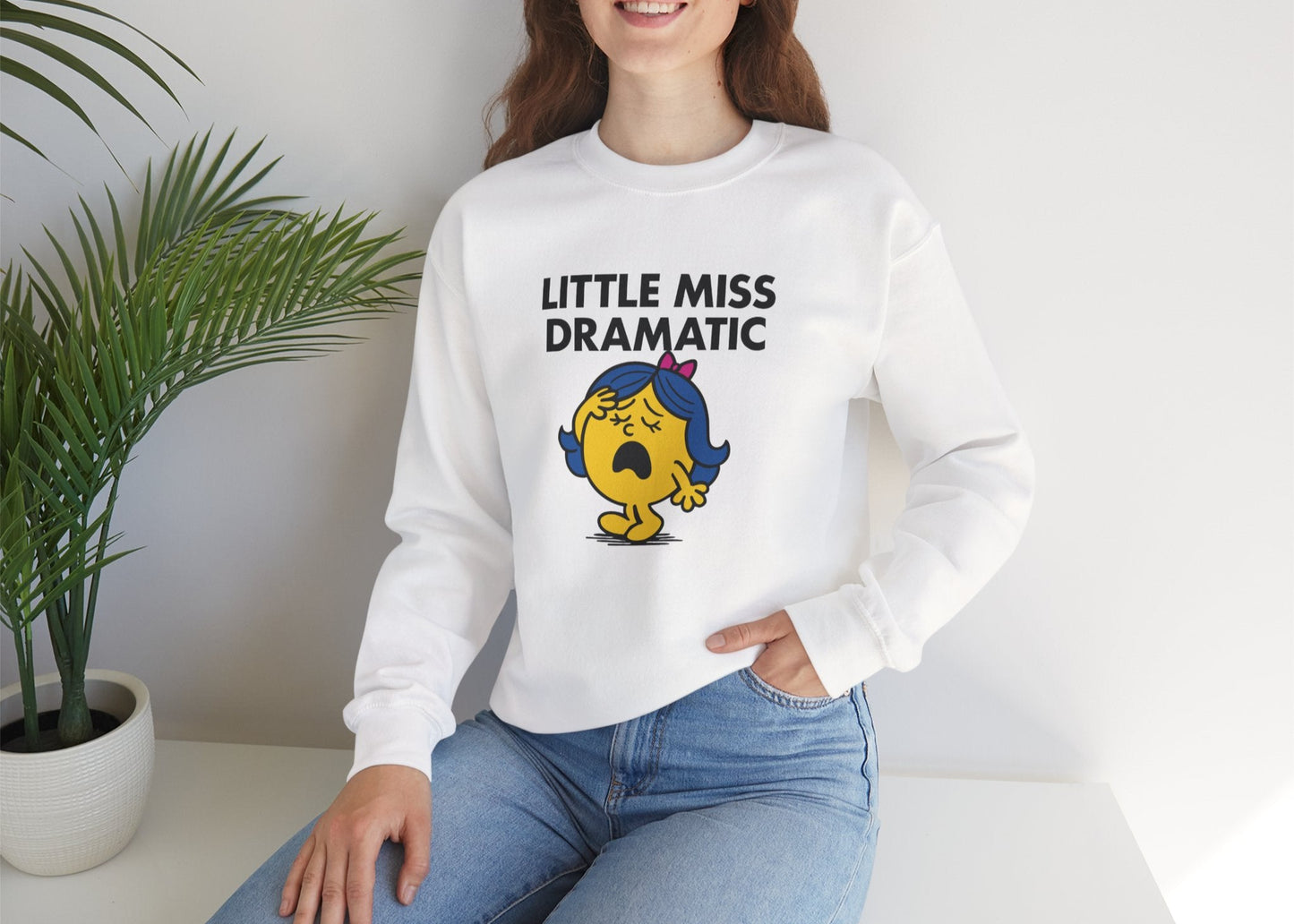 Person wearing the Little Miss Dramatic sweatshirt while seated casually. Part of the Little Miss Meme Character Collection. A Vivid Divergence Sensory Friendly Sweater Jumper.
