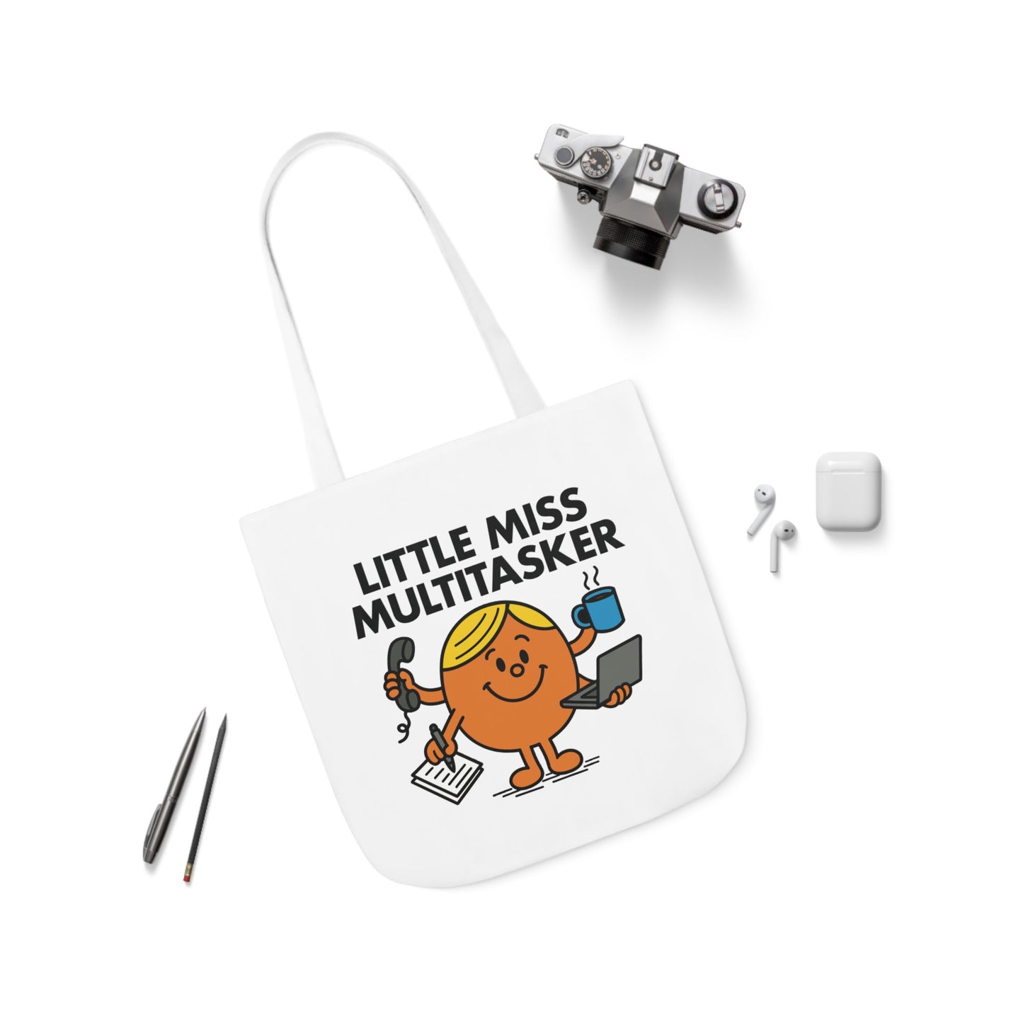 Flat lay of tote bag featuring Little Miss Multitasker surrounded by office-ready accessories. She’s got five tabs open in real life. Part of the Vivid Divergence Little Miss Meme Collection!