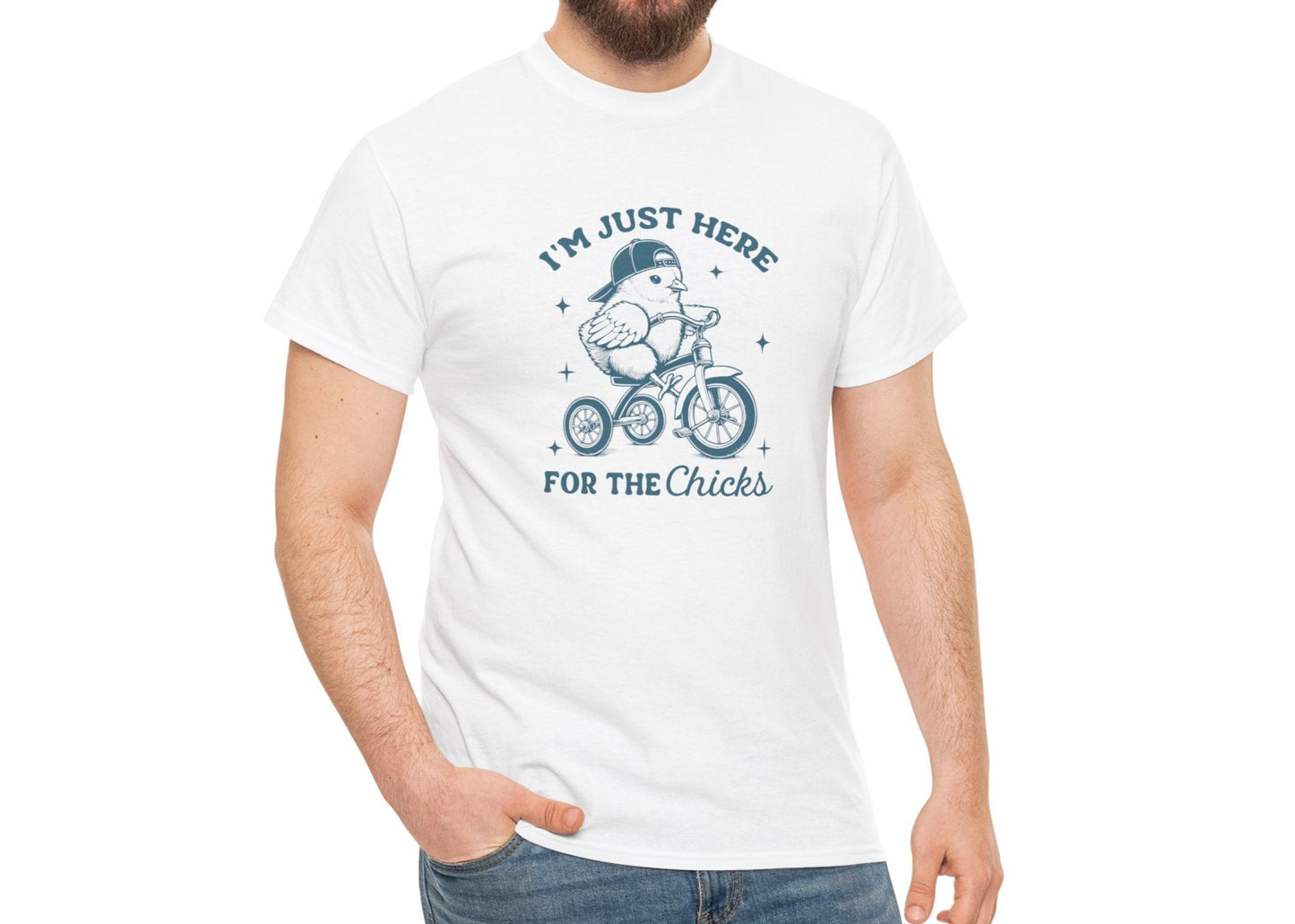 Man wearing a white Easter T-shirt showcasing a funny chick on a bicycle with "I'm Just Here for the Chicks" text, a perfect lighthearted holiday outfit. Hop into the season in style and shop Easter shirts online today!