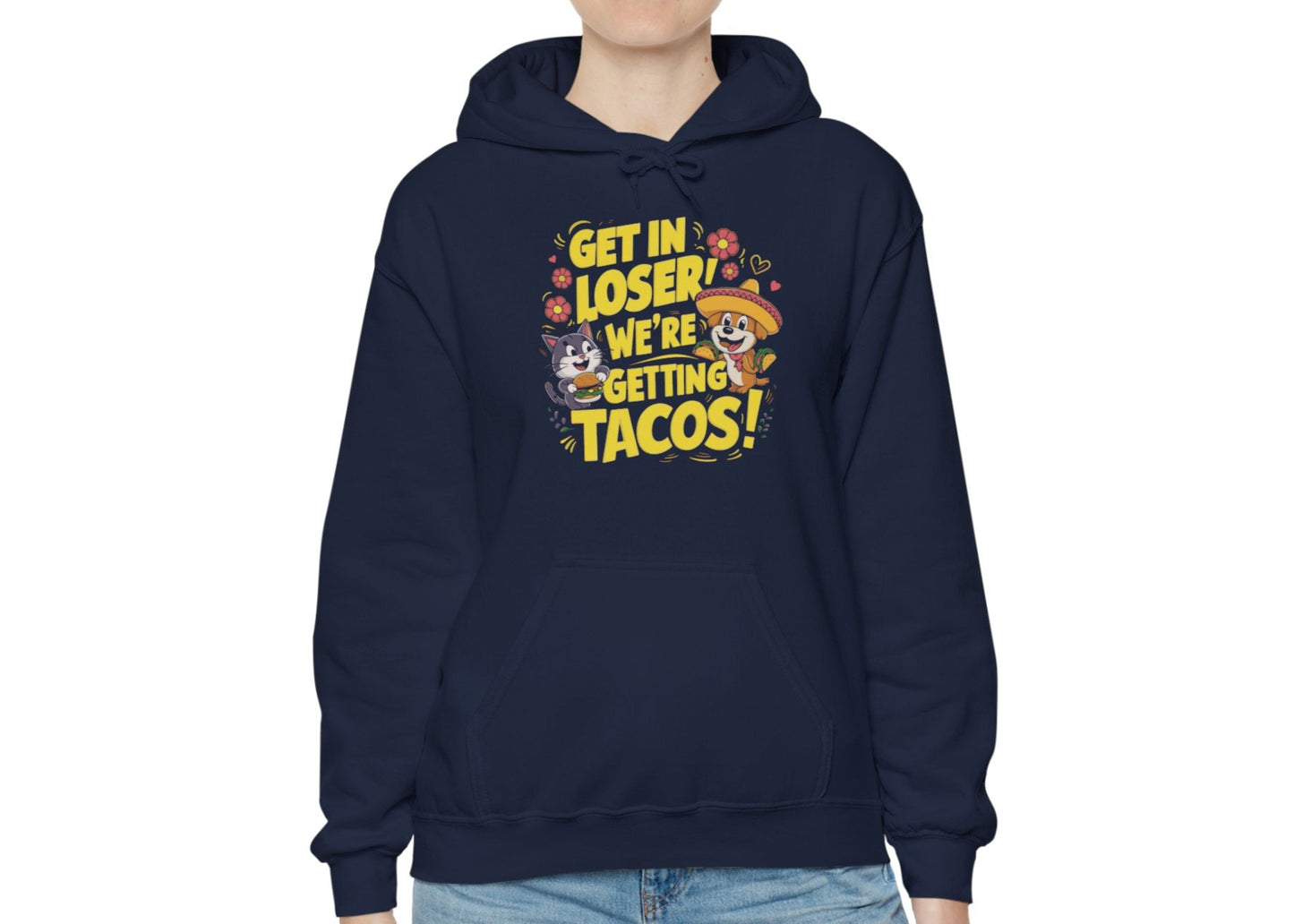 Model wearing a navy blue hoodie with colorful cartoon animals and the text "Get in Loser, We're Getting Tacos!" standing with hands in pockets. Part of the Vivid Divergence Sensory Friendly Unisex Hoodie Range.