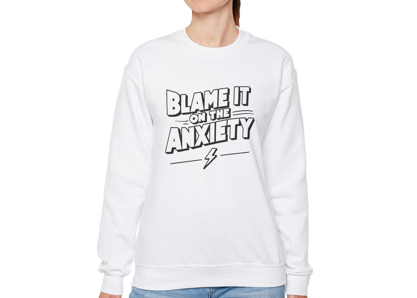 Model wearing a white sweatshirt with bold text that reads "Blame It on the Anxiety," standing with hands at sides. Part of the Vivid Divergence Sensory Friendly Unisex Sweater Jumper Range.