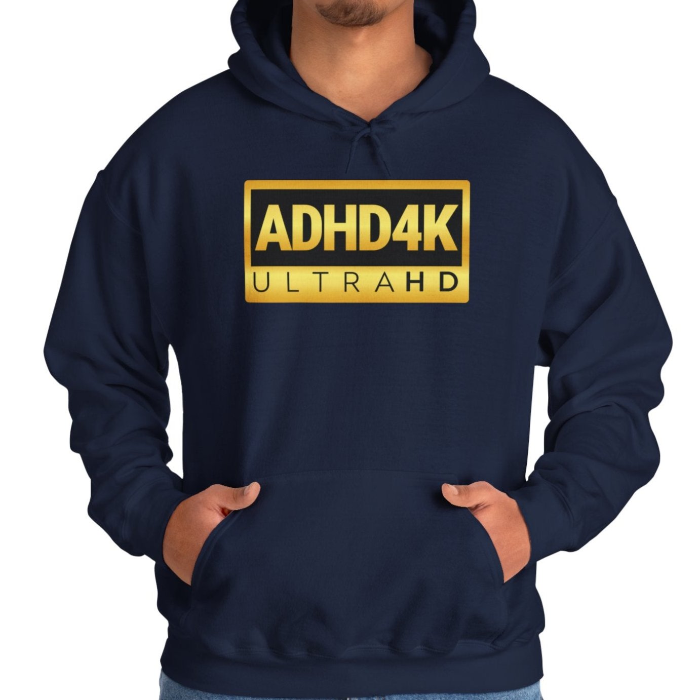 Model wearing a navy blue hoodie with the text "ADHD4K UltraHD" in bold yellow and black lettering inside a rectangular design. Part of the Vivid Divergence Sensory Friendly Unisex Hoodie Range.