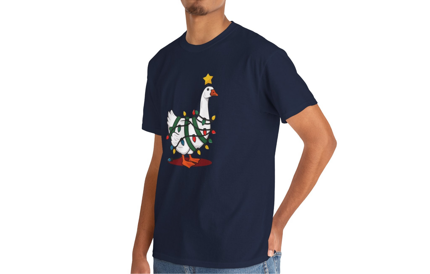 Model wearing a navy blue T-shirt featuring a festive illustration of a goose wearing a Santa hat and stringing Christmas lights, with the text "Goose on the Loose." Part of the Vivid Divergence Sensory Friendly Unisex Tees Range.