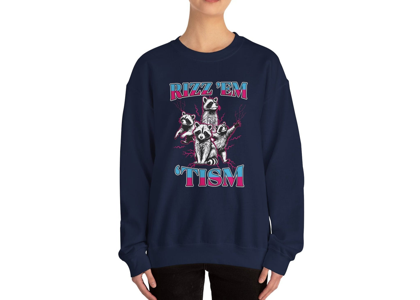 Model wearing a navy blue sweater jumper with the text "Rizz 'Em 'Tism" and a cartoon raccoon illustration striking a pose. Part of the Vivid Divergence Sensory Friendly Unisex Sweater Jumper Range.