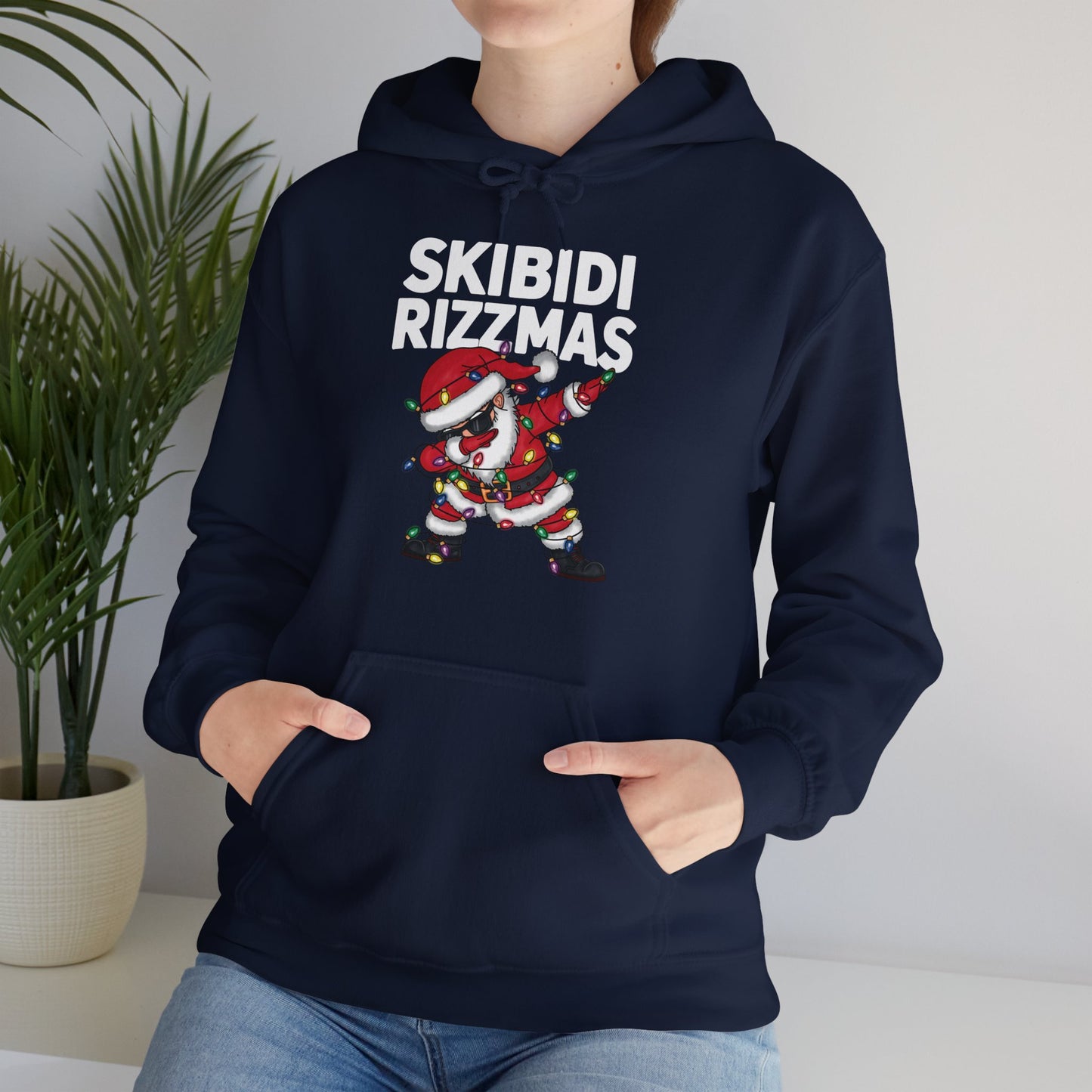 Model wearing a navy blue "Skibidi Rizzmas" hoodie, showing the front design with Santa dabbing. Part of the Vivid Divergence Sensory Friendly Unisex Hoodies Range.
