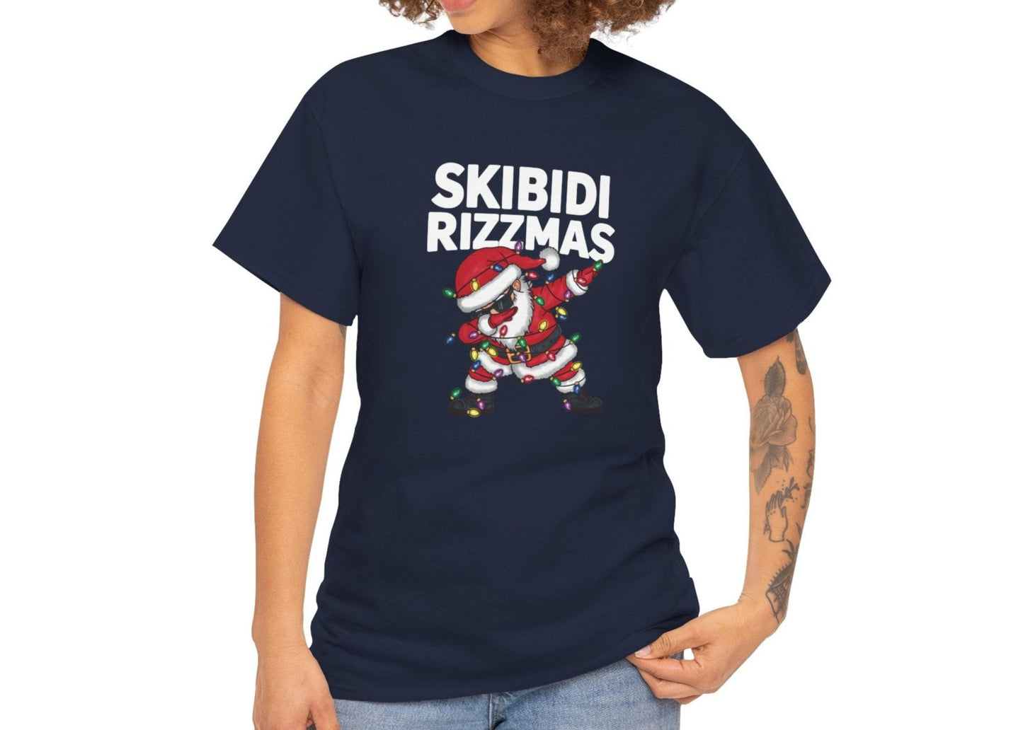 Model wearing a navy blue T-shirt featuring a dabbing Santa and "Skibidi Rizzmas" text. Part of the Vivid Divergence Sensory Friendly Unisex Tees Range.