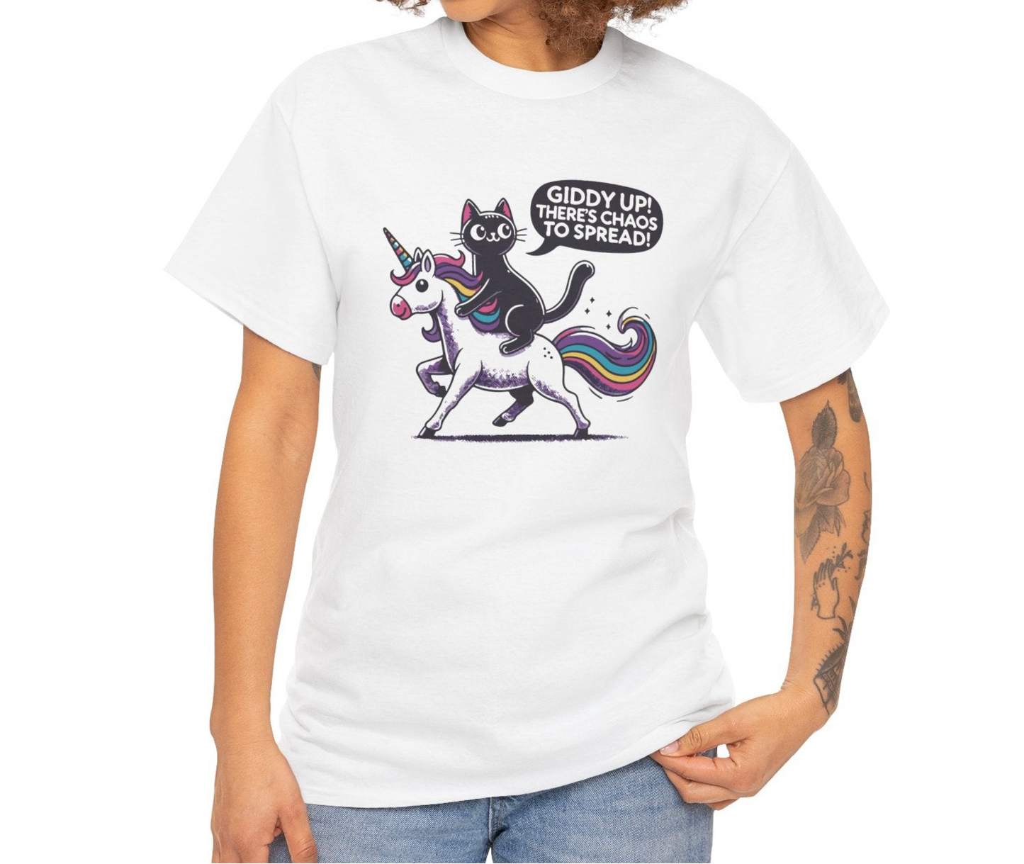 Person wearing a white T-shirt with a black cat riding a unicorn and the text "Giddy Up, There's Chaos to Spread." Part of the Vivid Divergence Sensory Friendly Unisex Tees Range.