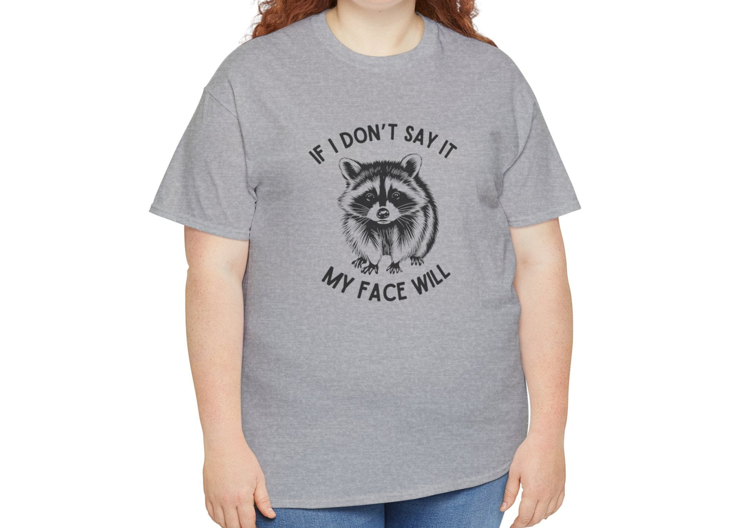 A person wearing a grey T-shirt with a raccoon face graphic and the text "If I Don't Say It, My Face Will." Part of the Vivid Divergence Sensory Friendly Unisex Tees Range.
Image Name: