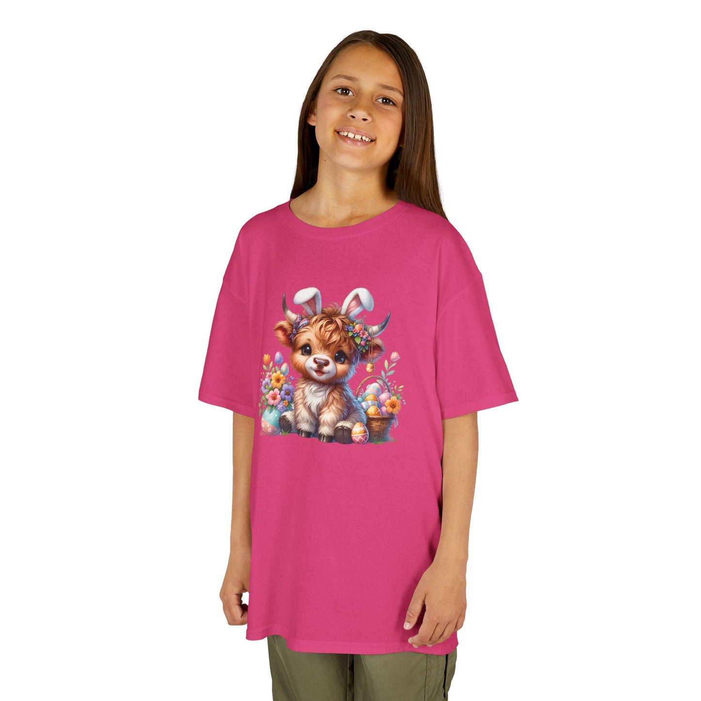 Child wearing a pink Easter T-shirt with a Highland cow, pastel-colored eggs, and flowers, a soft and stylish outfit. Hop into the season in style and shop Easter shirts online today!