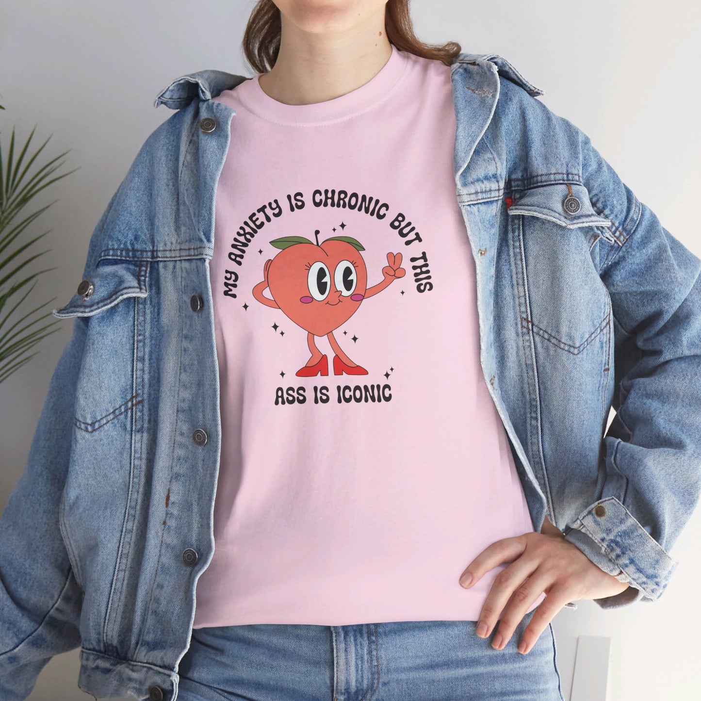Close-up of a person wearing a pink T-shirt with the text "My Anxiety Is Chronic But This Ass Is Iconic" paired with a denim jacket. Part of the Vivid Divergence Sensory Friendly Unisex Tees Range.