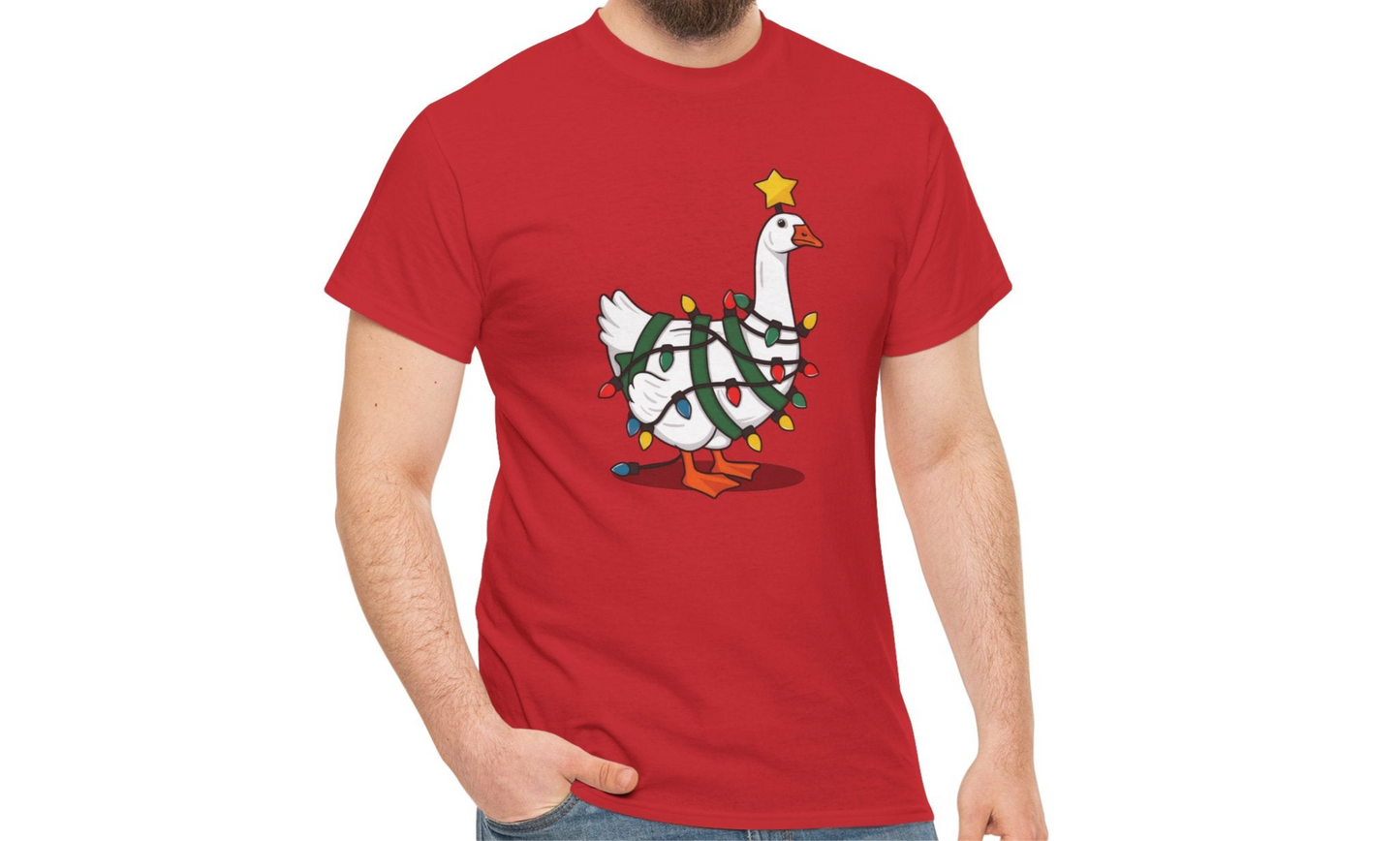 Model wearing a red T-shirt featuring a festive illustration of a goose wearing a Santa hat and stringing Christmas lights, with the text "Goose on the Loose." Part of the Vivid Divergence Sensory Friendly Unisex Tees Range.