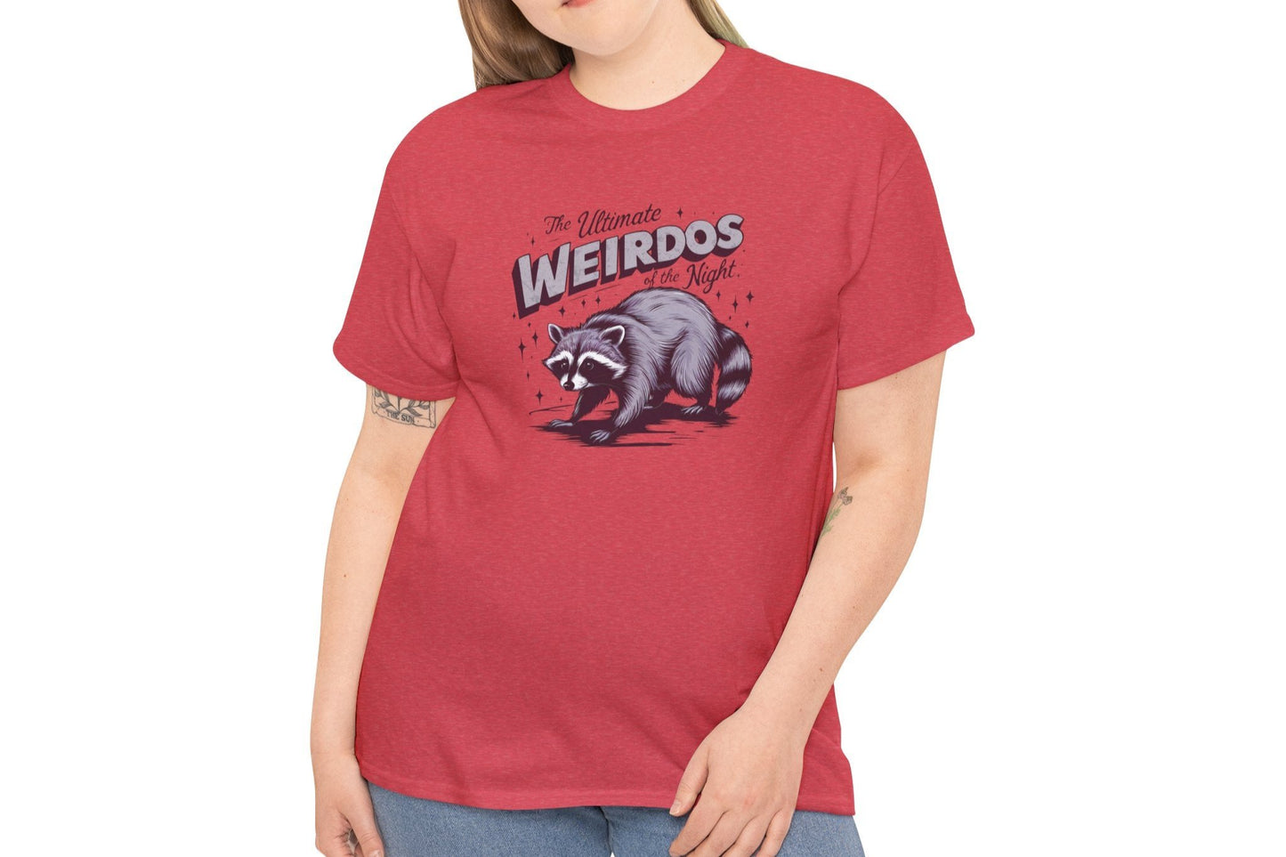 Model wearing a red T-shirt with "Weirdos of the Night" and an illustrated raccoon graphic in bold purple and white text. Part of the Vivid Divergence Sensory Friendly Unisex Tees Range.