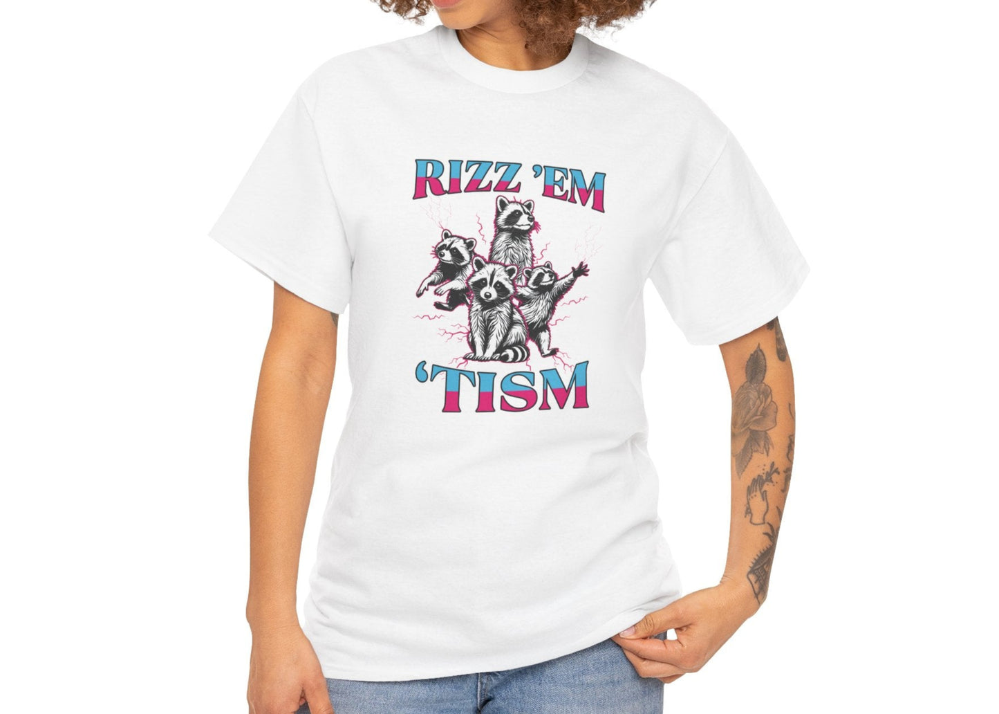Woman with curly hair wearing a white "RIZZ 'EM 'TISM" T-shirt with raccoon illustration, posing casually. Part of the Vivid Divergence Sensory Friendly Unisex Tees Range.