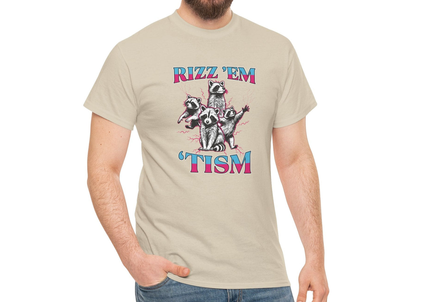 Man wearing a light gray "RIZZ 'EM 'TISM" T-shirt with raccoon illustration, smiling with a relaxed stance. Part of the Vivid Divergence Sensory Friendly Unisex Tees Range.