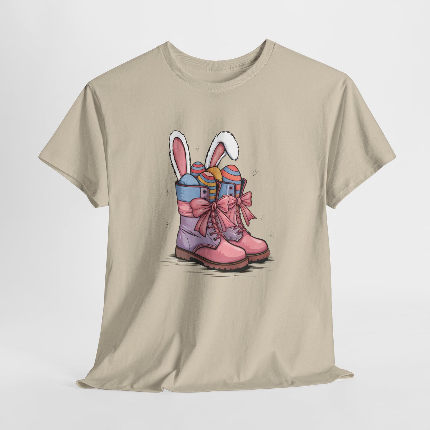 Sand T-shirt hanging, showcasing cowgirl boots with bunny ears and Easter eggs, a rustic and charming holiday outfit. Hop into the season in style and shop Easter shirts online today!